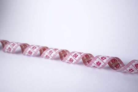 Red measuring tape on white background. Loss weight concept. Top view. Copy space. Isolated. . High...