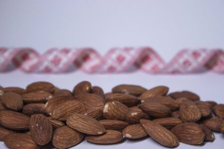 Red measuring tape with almonds . Diet and Healthy life concept. Top view. Copy space. Isolated....