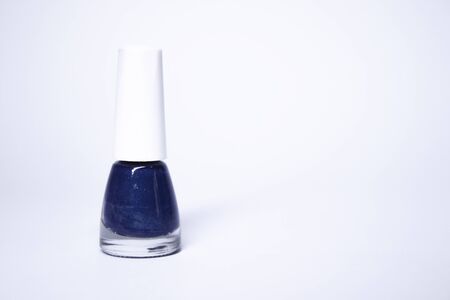 A bottle with blue nail polish on white background. nail lacquer. Nail manicure concept. Isolated, copy space. の写真素材