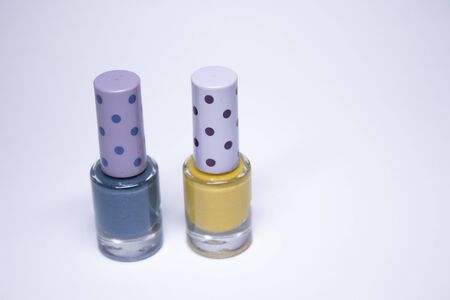 Bottles with blue and yellow nail polish on white background. nail lacquer. Nail manicure concept. Isolated, copy space.の写真素材