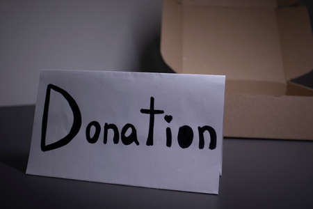 donation sign handwritten with black letters near a box. donation concept. Context of The Coronavirus Pandemic.の写真素材