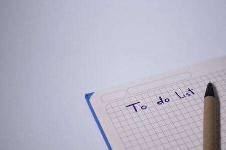 blue notebook with a pen on it and a sign To do list on it - handwritten. stationery concept. copy...