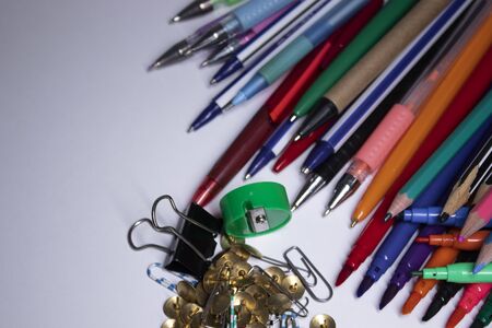 A pile of different stationery. multicolored markers, paper clips, pins, pencils, pens. High quality...
