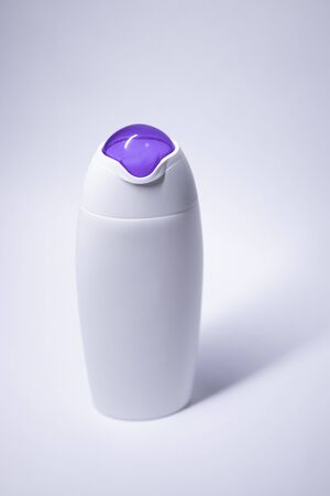 white shampoo bottle with purple neck and no label. body care and beauty concept. Copy space. High quality photoの写真素材