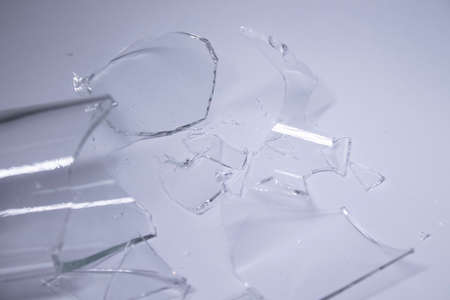 pieces of broken glass are scattered on a gray-white background. High quality photoの写真素材