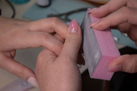 the process of doing manicure. Closeup of hands of professional manicurist, applying nail polish. Concept of doing manicure and fingernails cleaning. beauty concept. Gel polish, shellacの写真素材