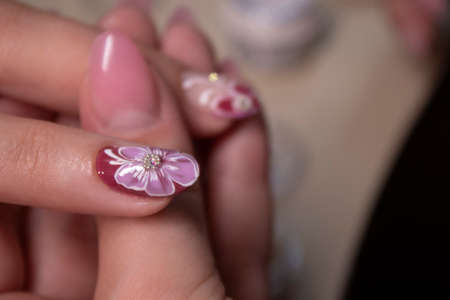 the process of doing manicure. Closeup of hands of professional manicurist, applying little stones on nails. Concept of doing manicure. beauty concept. Gel polish, shellacの写真素材