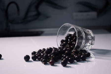 transparent glass with currants on a white table in a gray kitchen. High quality photoの写真素材