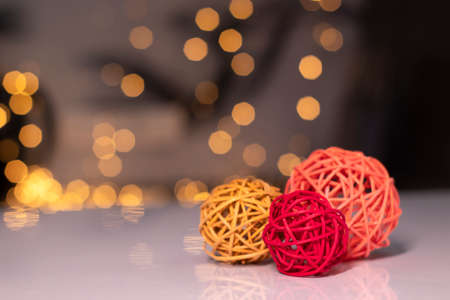 orange, red and pink wicker balls for decoration on a background of golden bokeh.の写真素材