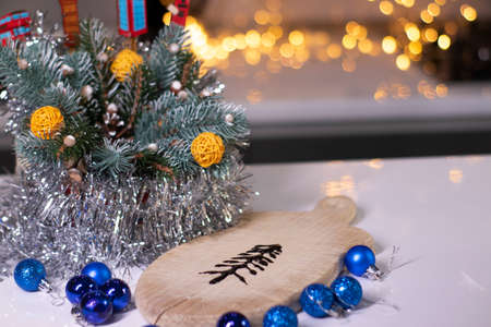 christmas tree made of chocolate on a wooden board next to new years decorations.