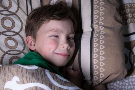 portrait of a nine year old blond boy in a bed.の写真素材