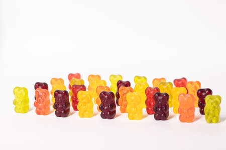 army ranks of colorful bright gummy bears isolated on white background.の写真素材