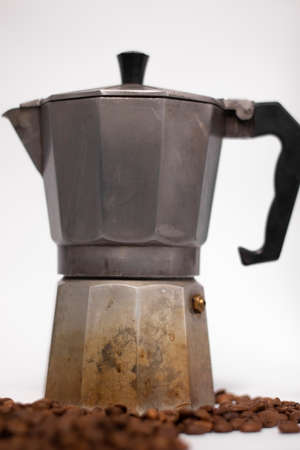 geyser coffee maker or moka pot isolated on white background with coffee beans nearby.
