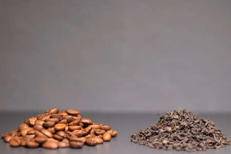 pile stack of dried tea leaves and roasted coffee beans seeds: theine vs caffeine. background.の写真素材