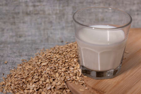 pile of raw oatmeal near a glass of milk. healthy breakfast. vegan oat milkの写真素材