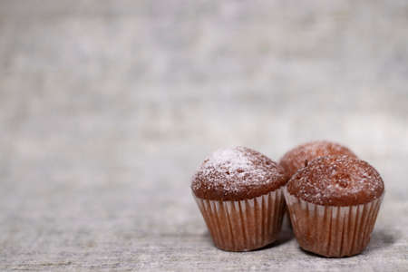 three muffins cupcakes covered in powdered sugar. sweet bakeryの写真素材