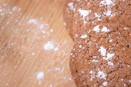 oatmeal cookies covered in powdered sugar on wooden stand board. concept of sweet bakeryの写真素材