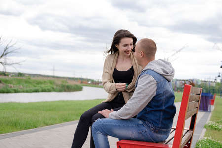 beautiful young couple sitting on a bench in the park.の写真素材