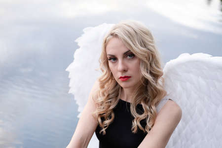 fallen angel. girl in black with white angel wingsの写真素材