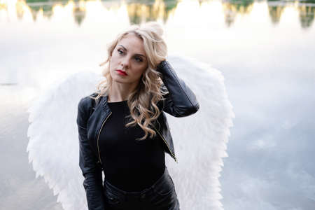 fallen angel. girl in black with white angel wingsの写真素材