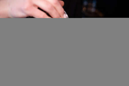 latte art by barista. pouring milk in coffee. dark coffee house.の写真素材