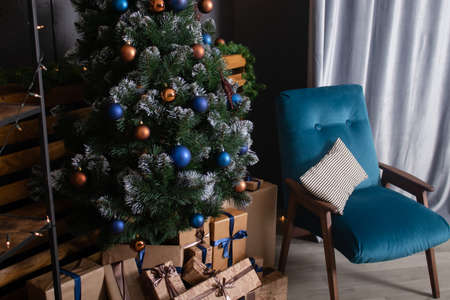 Stylish loft room interior with beautiful Christmas tree. dark blue and brown and gold colors. new years atmosphere decorationの写真素材
