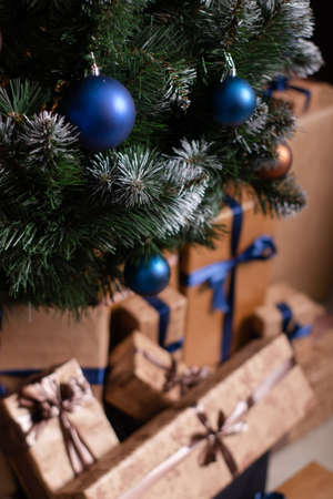 pile of gift boxes near christmas tree. presents for new year. beige and brown colors.の写真素材