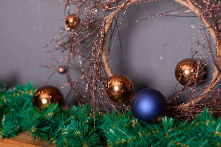 golden Christmas wreath near christmas tree branches and decor - balls and bubbles in blue and brown colors. new year decoration.の写真素材