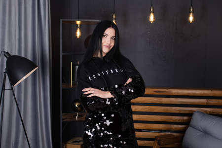 young attractive woman in black in grey loft room. trendy clothes. fashion female portrait.の写真素材