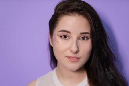 portrait brunette woman girl female on Very Peri background. with sequins on face. trendy color 2022. light purple. violet.の写真素材