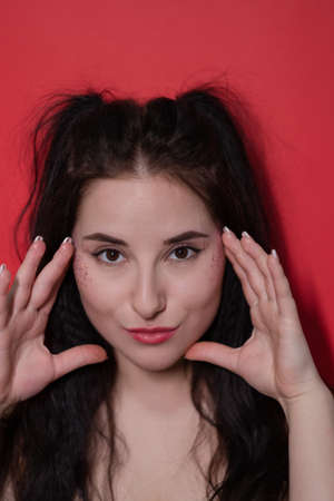 attractive brunette woman on red background. portrait of beautiful girl.の写真素材
