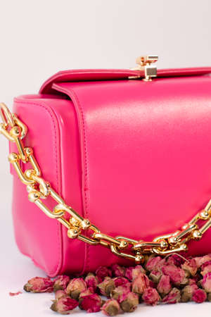 fashion photo. pink handbag surrounded by little roses flowers near. isolated on white. composition photographyの写真素材