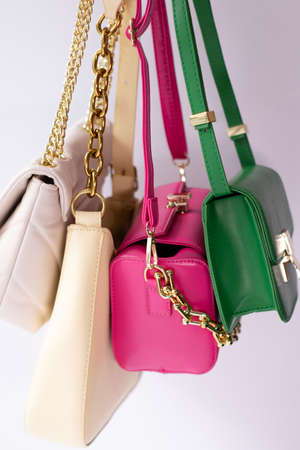 woman hand holding set of colorful bags. product composition photography. handbag and purse for women.の写真素材