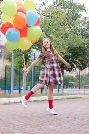 Teenage girl with colorful helium air balloons having fun outdoors. Tween party. enjoying summer.の写真素材