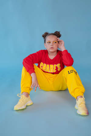 teenage girl in fashion stylish bright clothes. little lady in red and yellow on blue background....