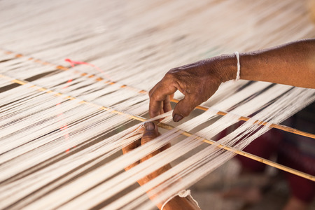 hand and white silk thread in sewing or weaving machine,texture,background