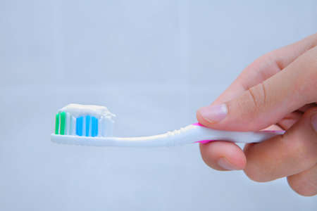 hand holding tooth brush with paste on it