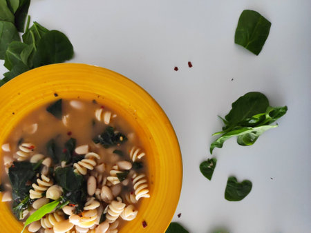 Yellow bowl for a warm Italian beans and pasta soupの写真素材