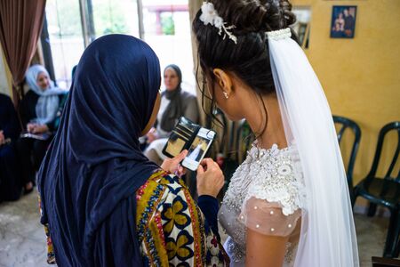 Raamla, Israel - 09.17.2018. Arabian wedding, bride with her frien looking photos on the phoneのeditorial素材