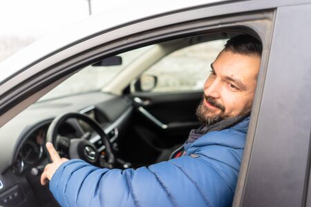 Handsome hipster Man in blue coatsitting on the driver's seat