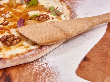 Pizza on wood decorated with spreaded wheatの写真素材
