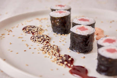 Fresh sushi rolls on a plate with soy sauce, mood shot