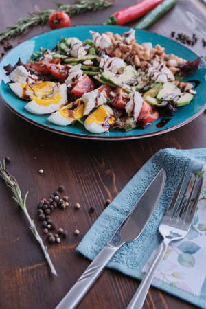 Vegetable salad with eggs and walnuts on wooden table, daylight shotの写真素材