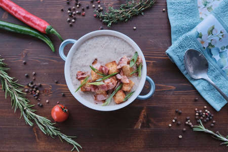 Cream soup with bacon and croutons decorated on wood