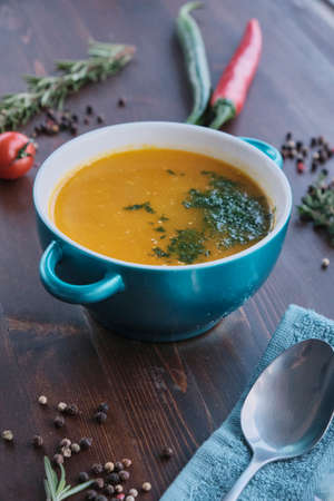 Carrot soup on wooden background decorated with spicesの写真素材