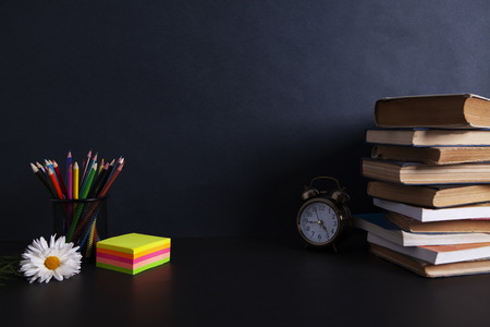 books with an alarm clock on desktopの写真素材