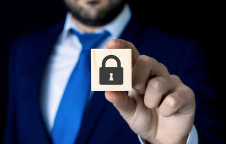 a businessman holds a padlock; security icon; business conceptの写真素材