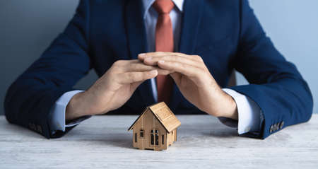 businessman holds a house in his hand; business conceptの写真素材