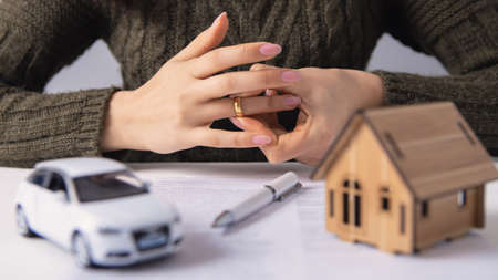 woman removes a wedding ring, property section, divorceの写真素材