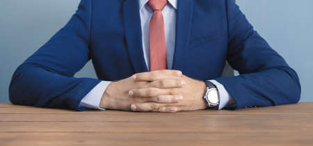 businessman sits at the table with folded armsの写真素材